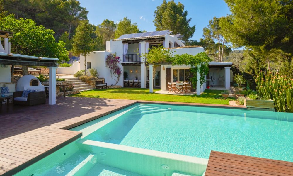 Modern villa with a pool and garden area surrounded by trees